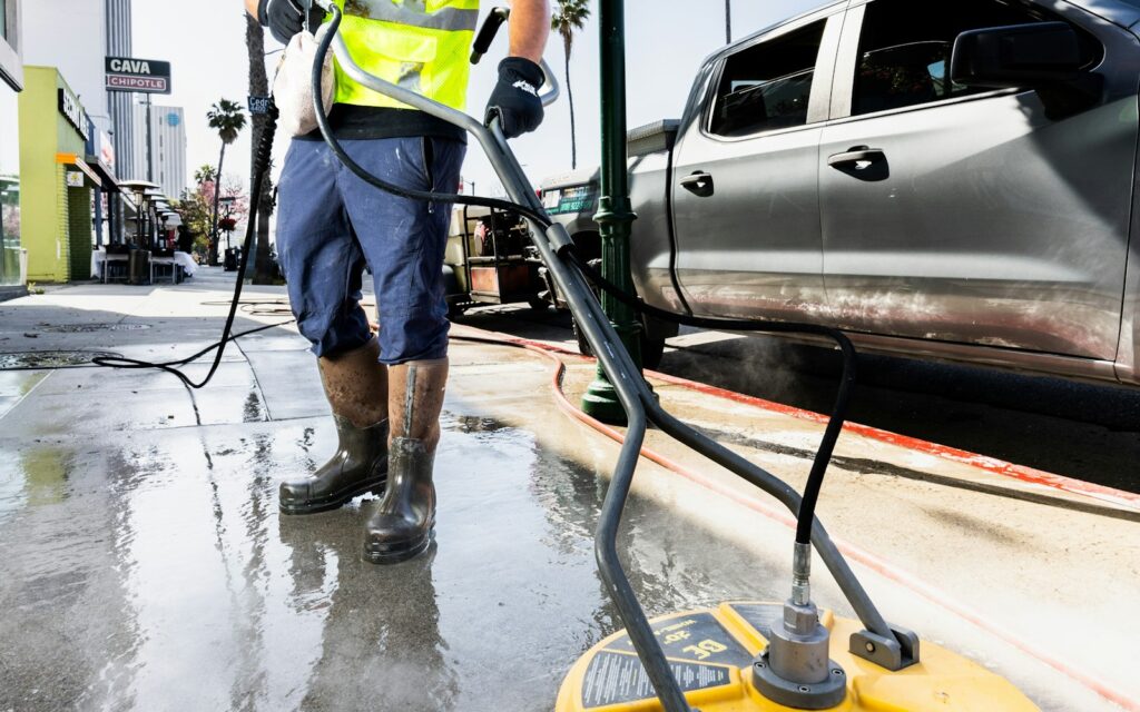 Pressure washing crew cleaning a commercial sidewalk with a surface cleaner